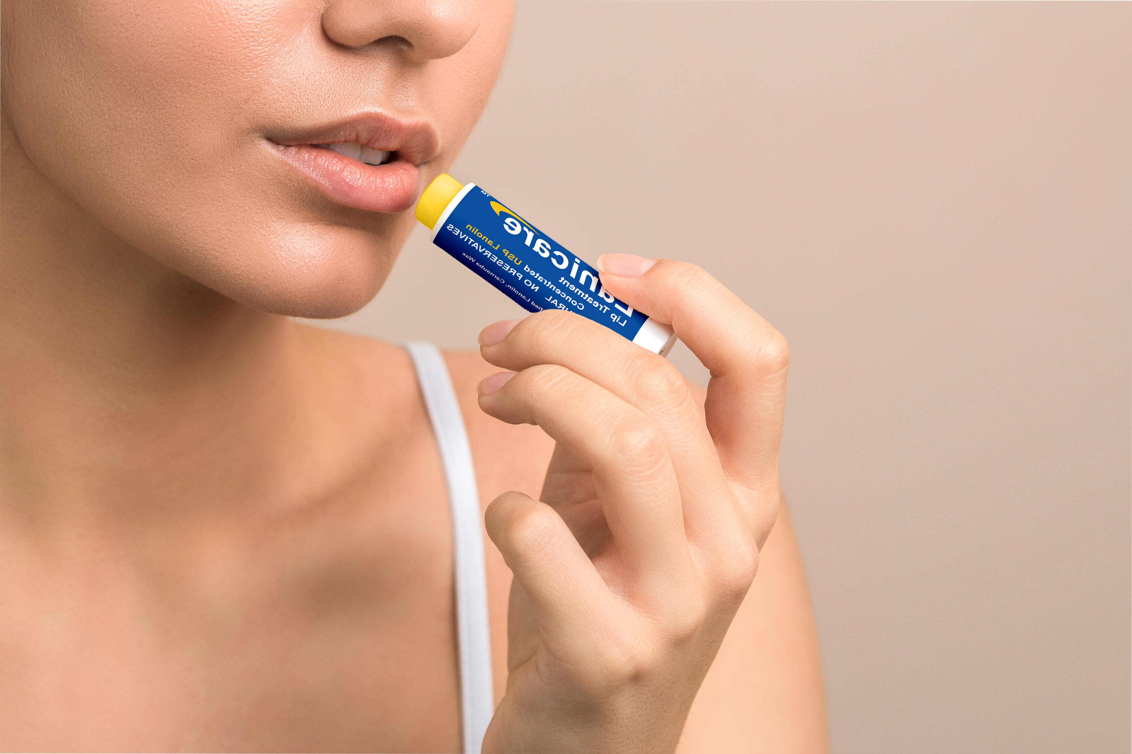 image of a person bringing Lanicare lip balm tube up to her lips.