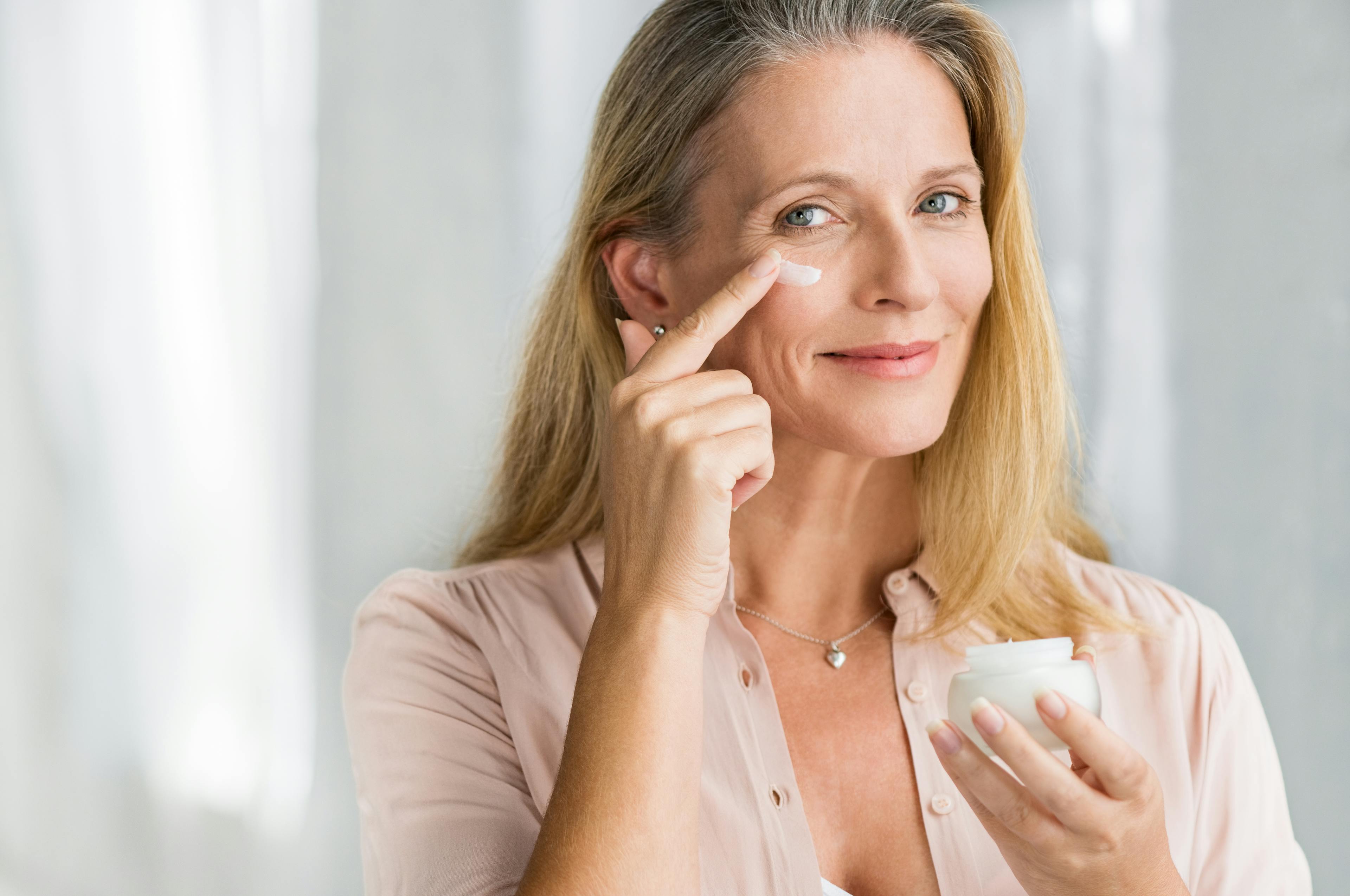 Picture of a woman rubbing cream on her face.